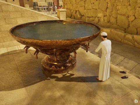 Un sacerdote que se purificaba se paraba debajo de uno de los 12 grifos del lavacro y dejaba que el agua corriera sobre sus manos y pies mientras ponía su mano derecha sobre su pie derecho y su mano izquierda sobre su pie izquierdo. – Número de diapositiva 16