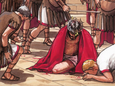 Entonces los soldados del gobernador se llevaron a Jesús. Le quitaron sus vestiduras, pusieron un manto escarlata alrededor de él, una corona de espinas en la cabeza y arrodillándose ante él, se burlaban,  "Salve Rey de los Judíos ". – Número de diapositiva 2