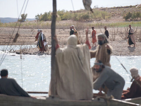 Una gran multitud, muchos de ellos peregrinos que se dirigían a la fiesta de la Pascua en Jerusalén, observó la barca y la siguió a pie por la costa para encontrarse con Jesús. – Número de diapositiva 2